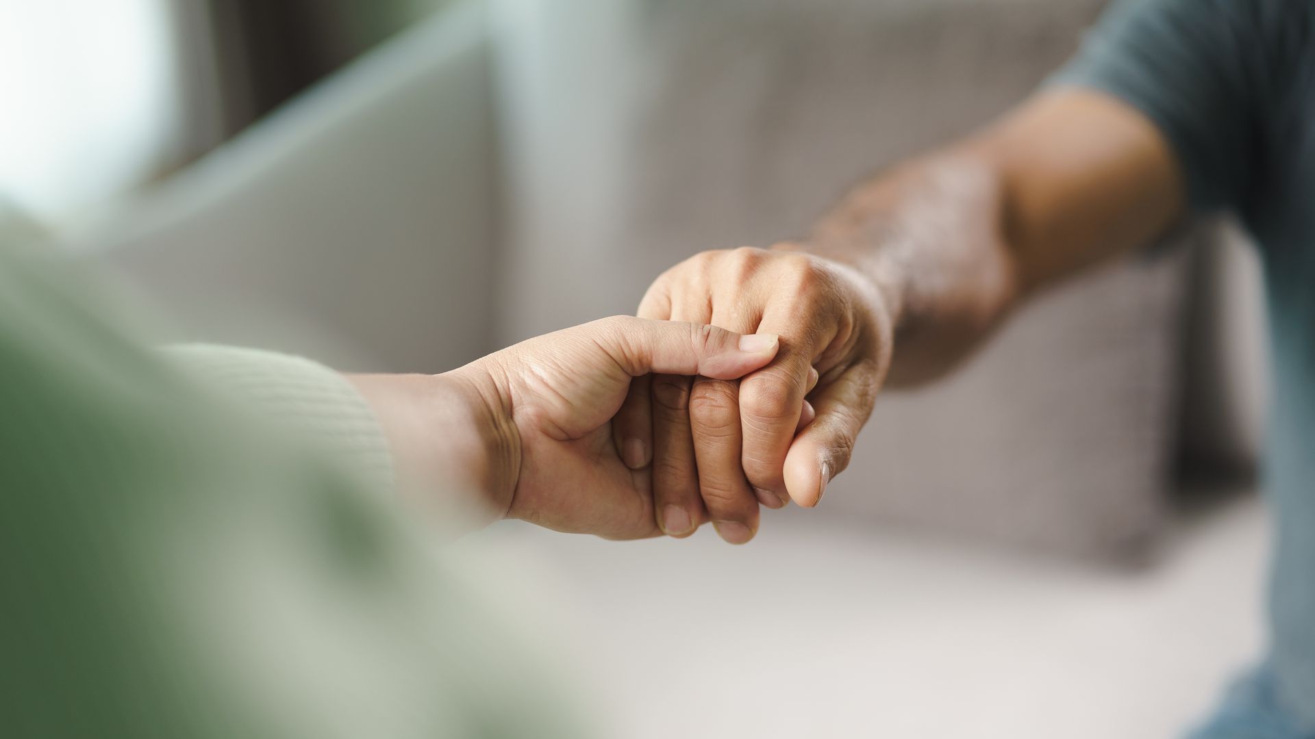 Zwei Menschen, die Händchen halten – ein Zeichen der Unterstützung.