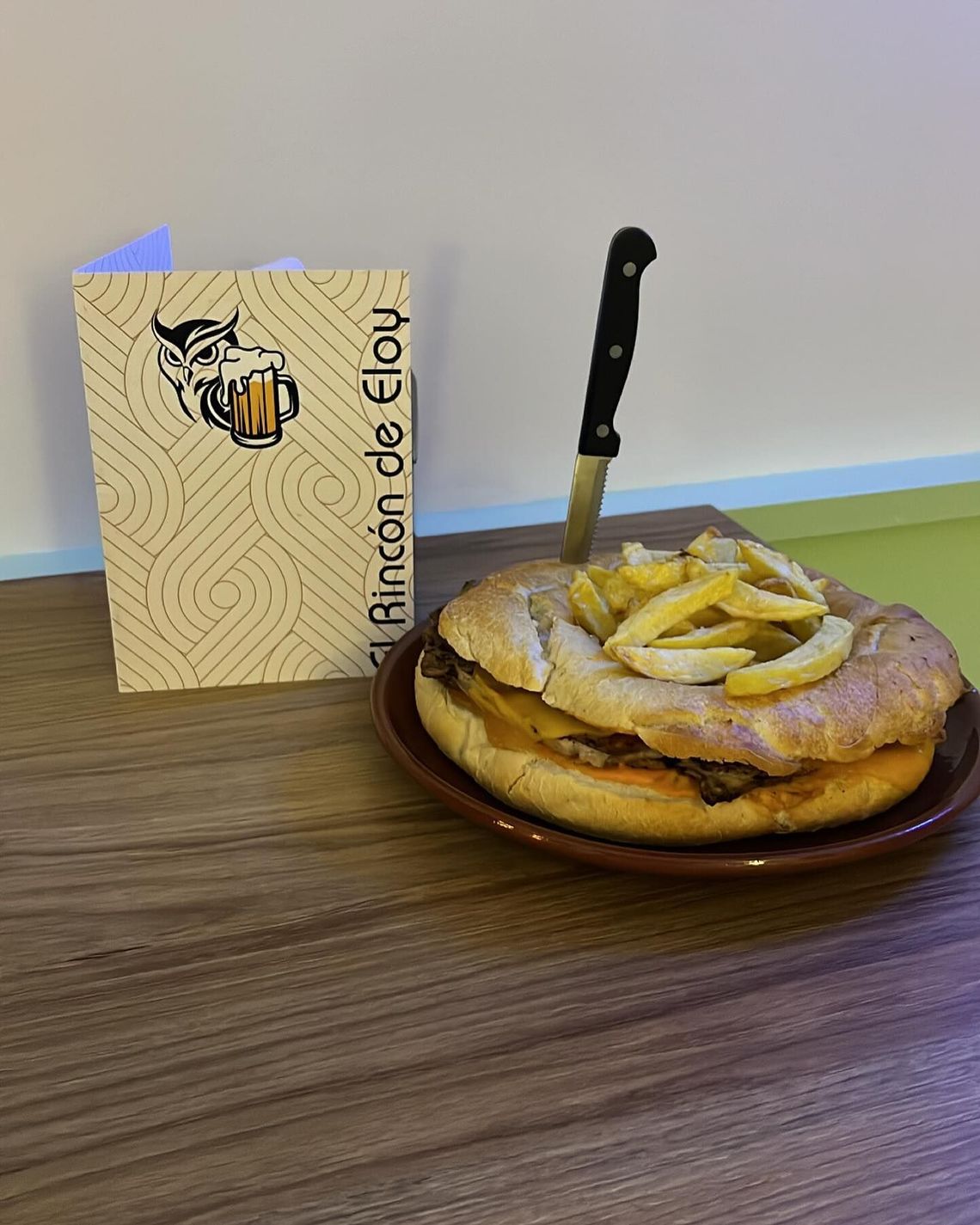 Pastel de postre con rodajas de manzana y cuchillo junto a una caja de Fleur sobre una mesa.