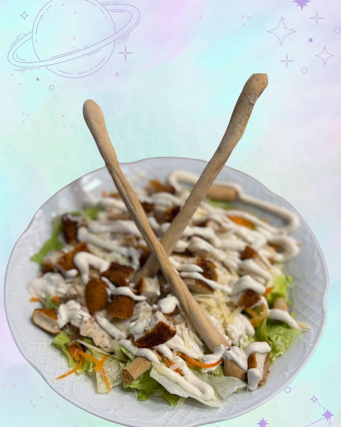 Un bol de ensalada con aderezo cremoso y dos pinzas de madera sobre un fondo pastel.