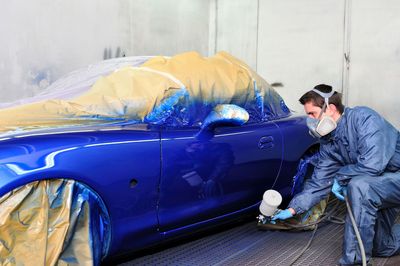 Rotes Auto-Rohteil auf einem Montageband, Motorhaube und Türen geöffnet.