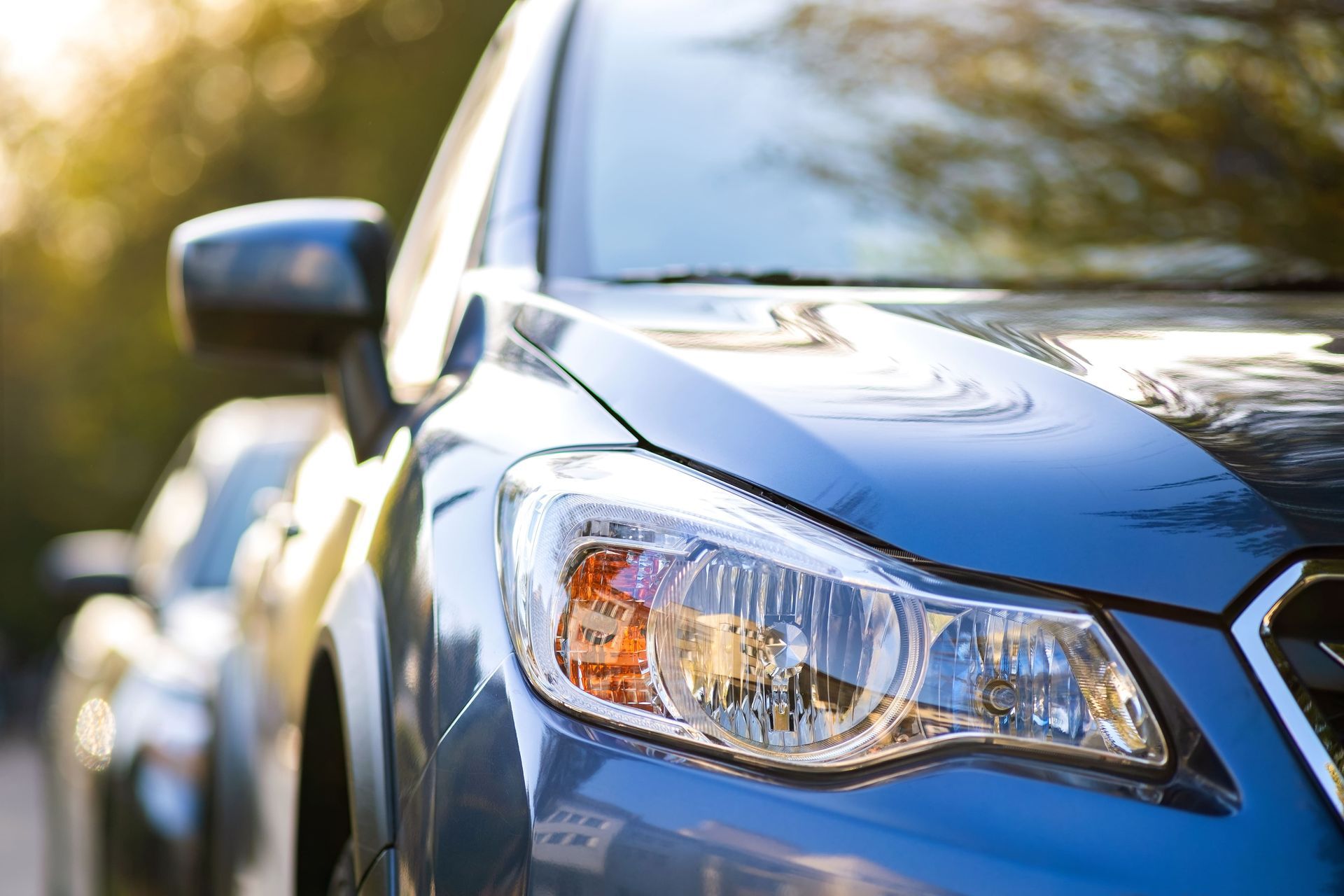 Un gros plan d'une voiture bleue garée sur le bord de la route.