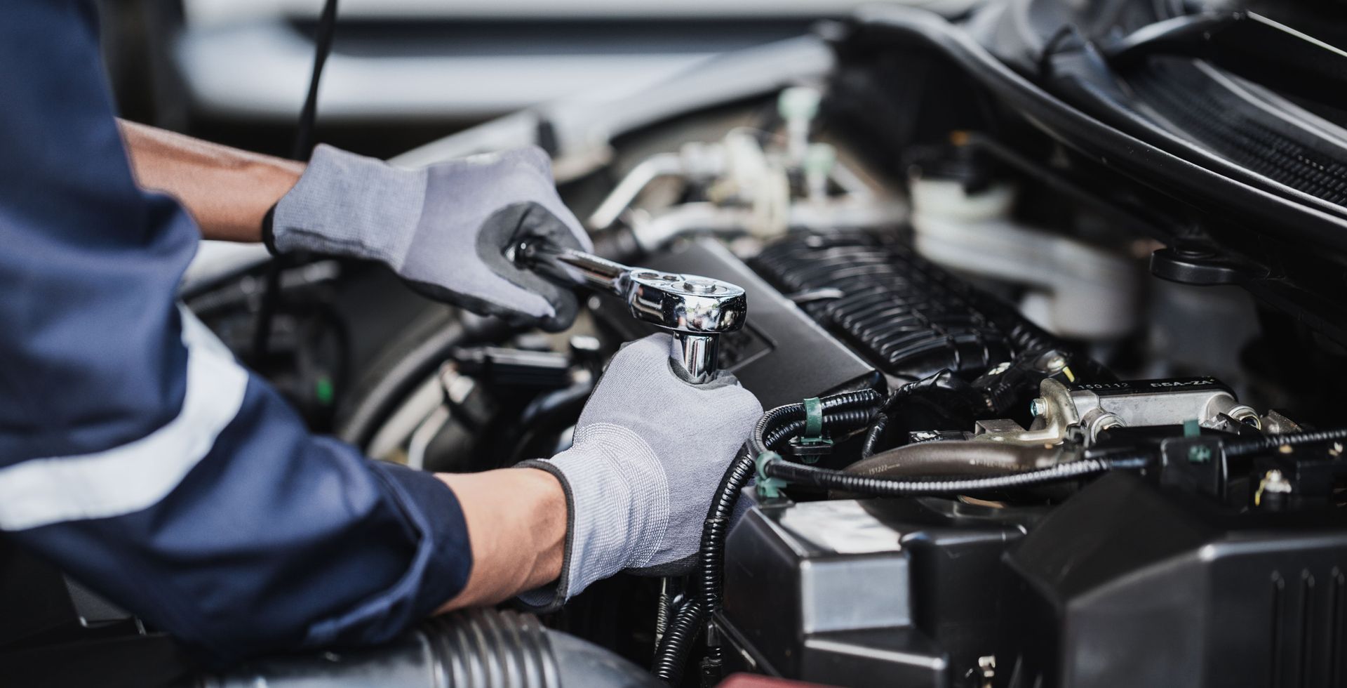 Un mécanicien travaille sur le moteur d'une voiture.