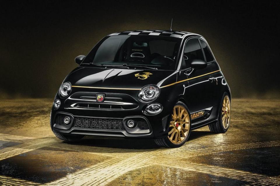 Une voiture noire et dorée est garée sur un sol mouillé.