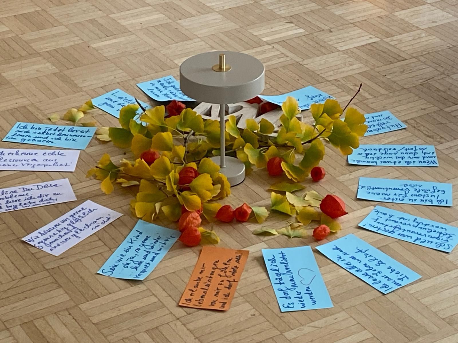 Workshop-Situation: handbeschriftete bunte Karten liegen im Kreis auf dem Holzboden