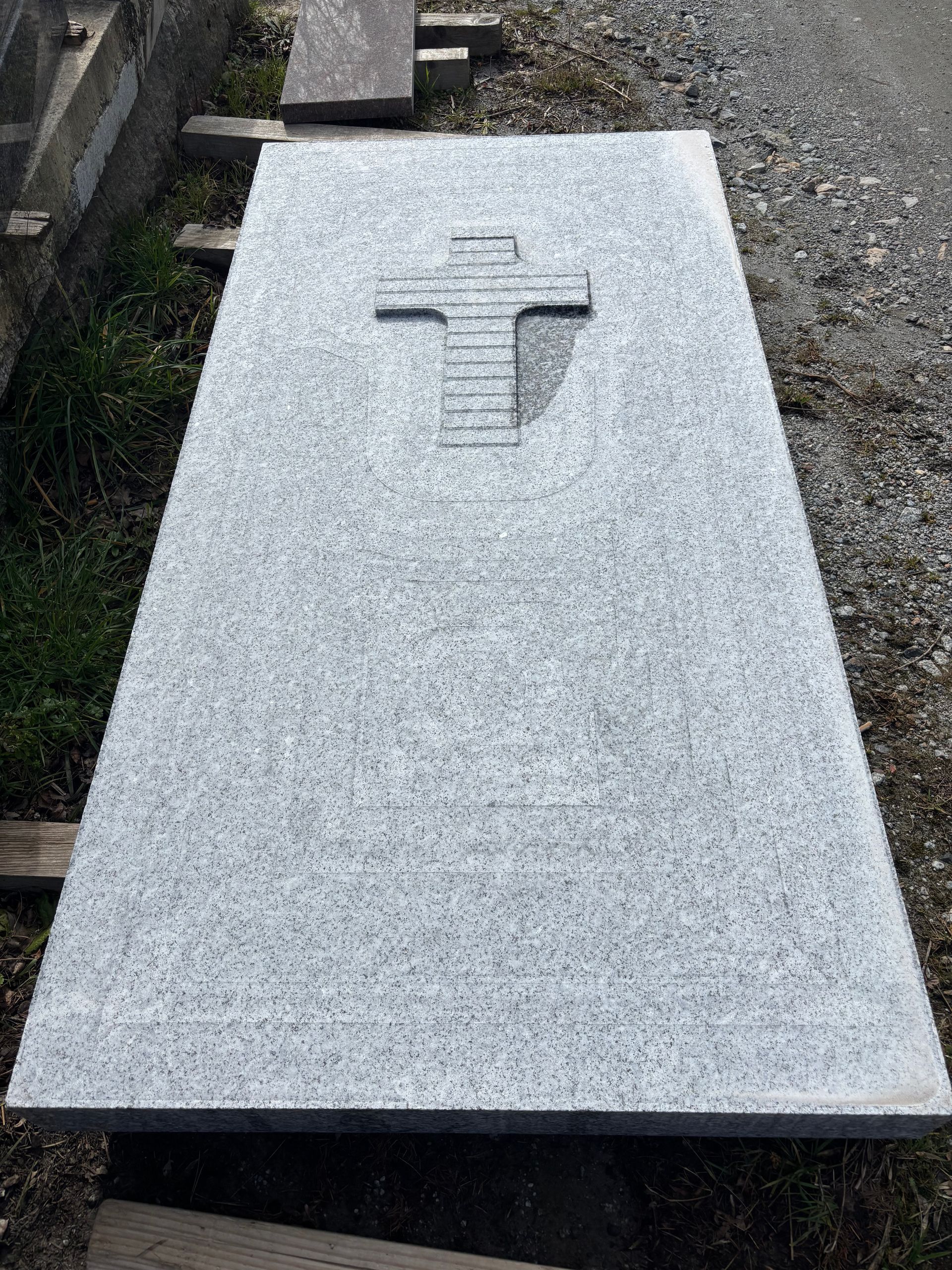 Pierre tombale en granit noir avec un design incurvé et sculpté.