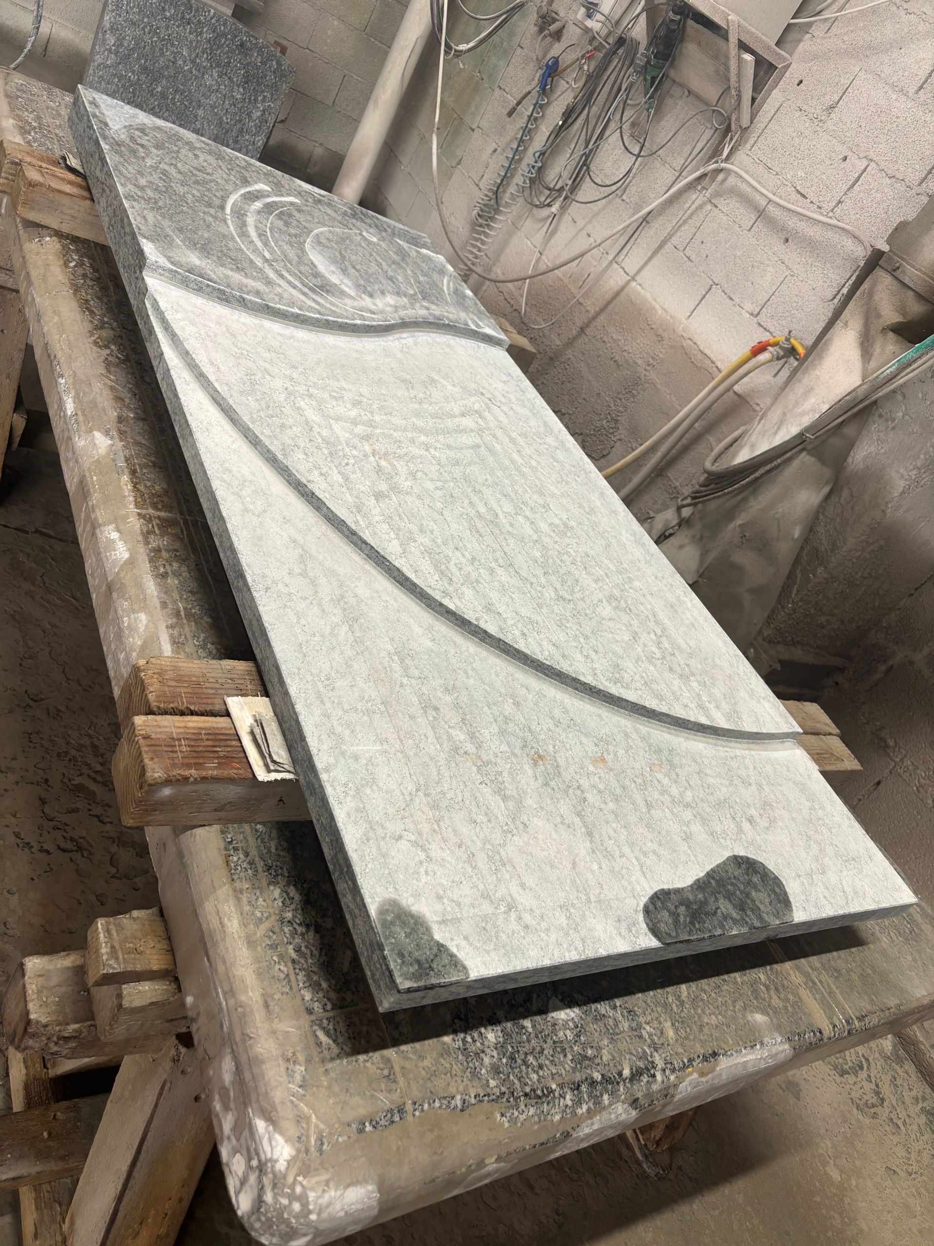 Dalle de granit rose avec un motif en relief et incurvé, probablement pour un monument.