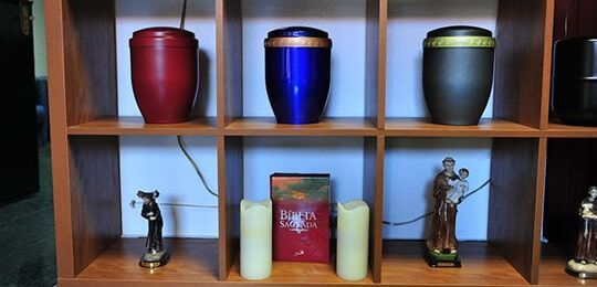 Uma prateleira com urnas e velas