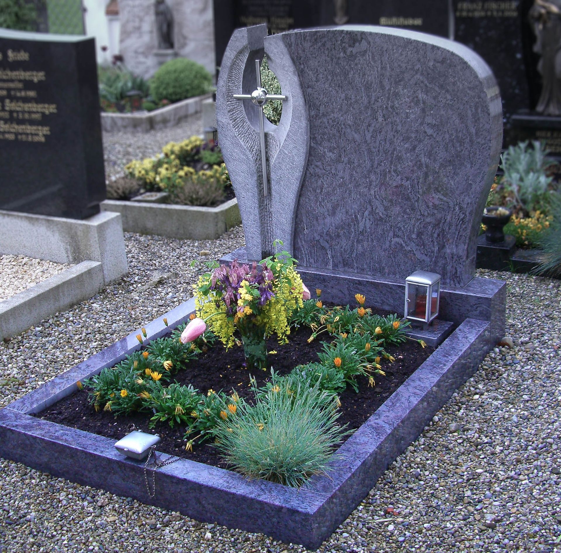 ein schwarzes Grabstein mit einem Kreuz darauf