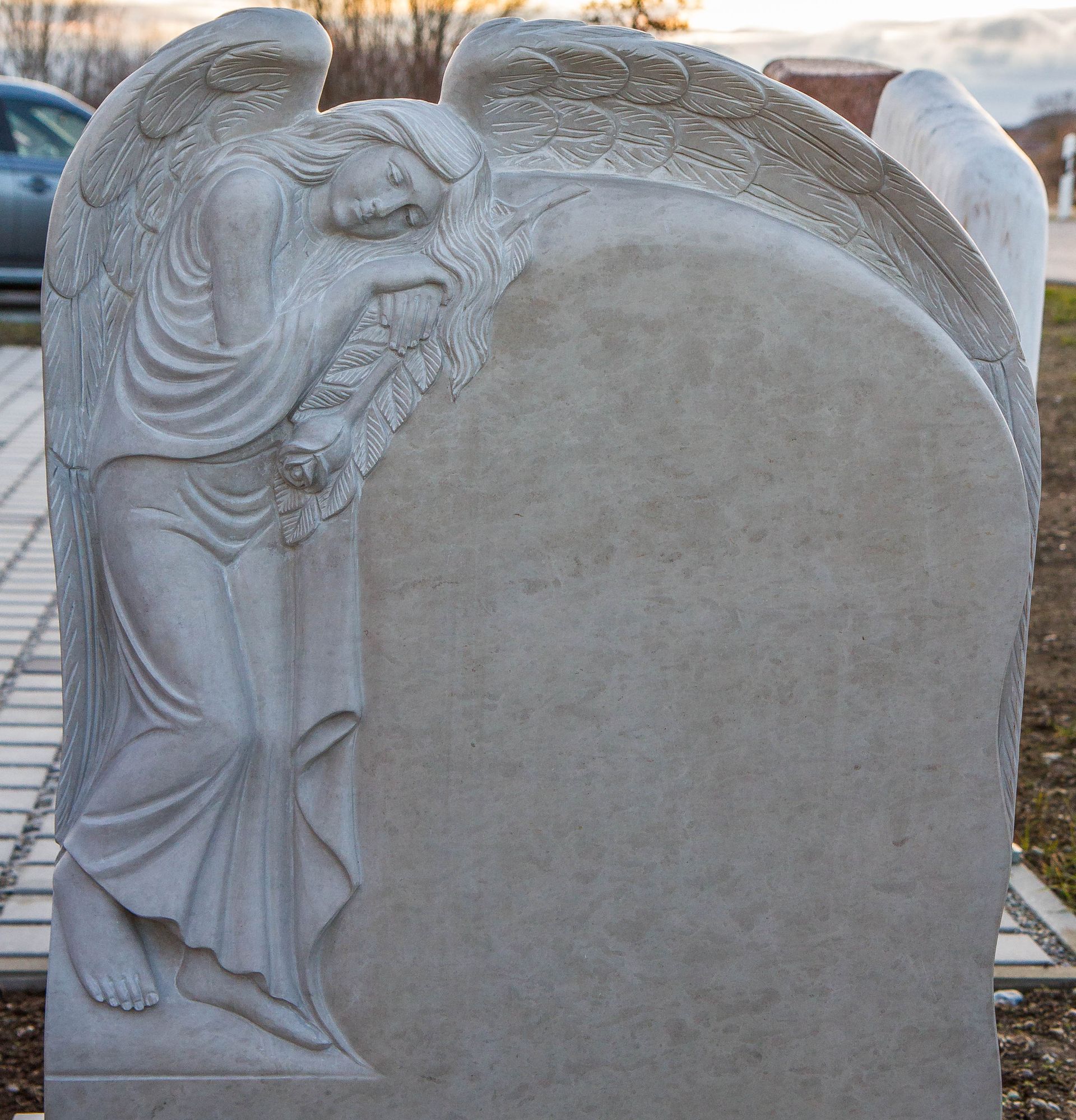ein Grabstein mit einer Statue eines Engels darauf