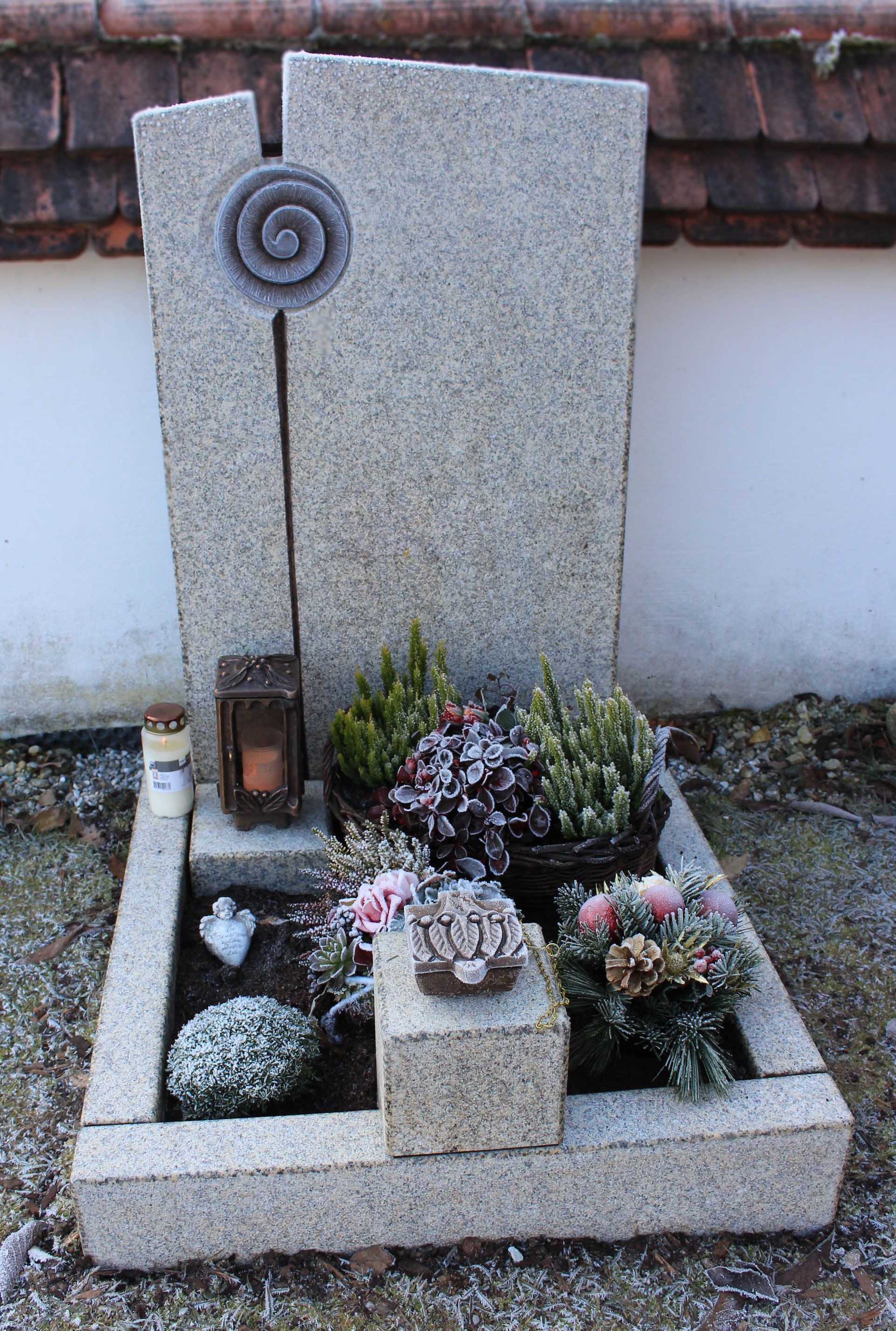 ein Grabstein mit Blumen und Kerzen darauf