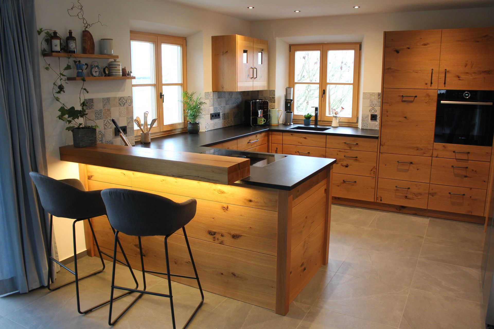 eine Küche mit Holzschränken und einer Bar aus Stein mit Stühlen 