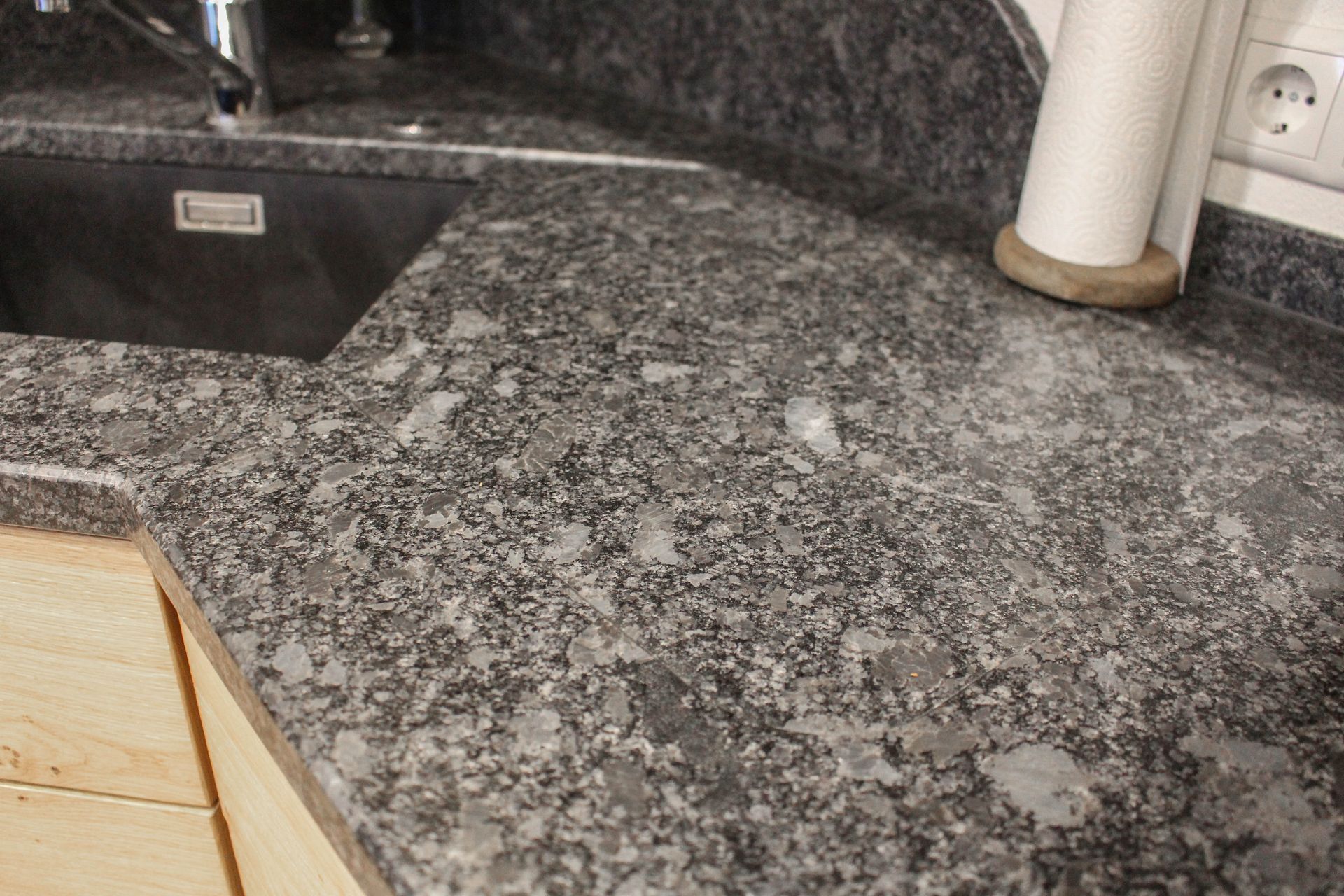 eine Küche mit einem Spülbecken und einer Granitarbeitsplatte .