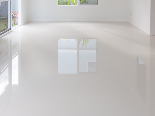 Une pièce blanche et lumineuse, vide, avec un sol en carrelage.