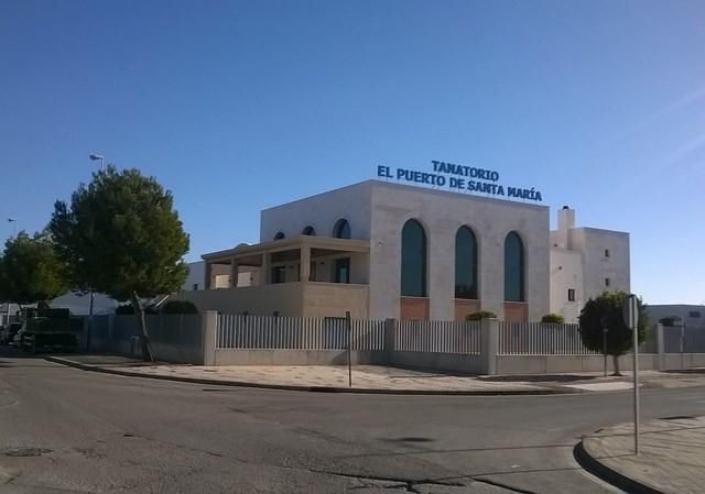 Exterior of El Centro Transitorio de Santa María, a cream-colored building behind a white fence under a blue sky