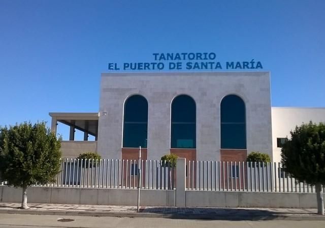 Tanatorio El Puerto de Santa María building with blue sky and white fence