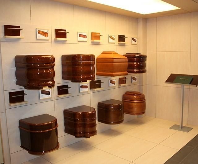 Exposición de contenedores de madera marrón apilados en una sala de exposiciones minimalista de un museo.