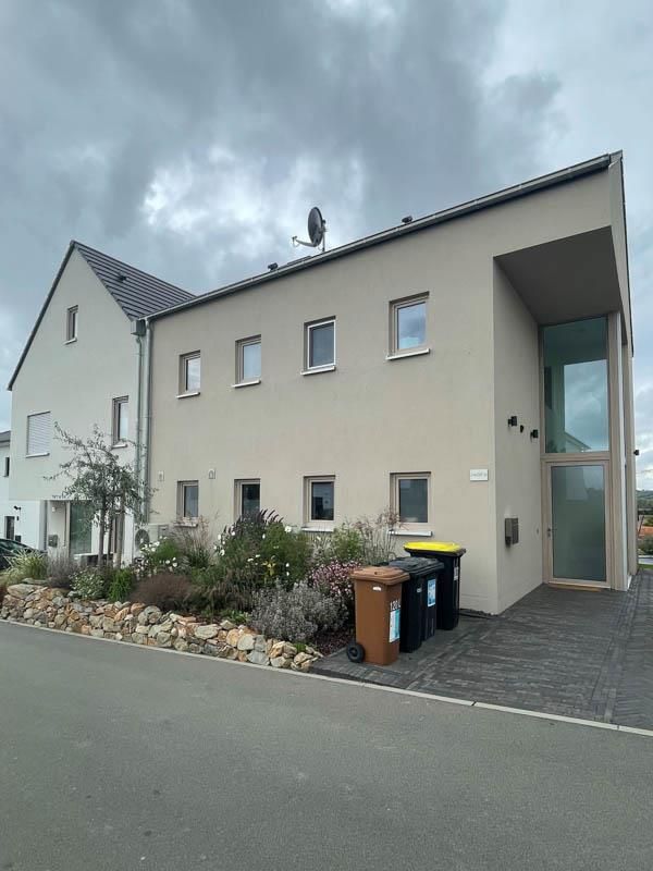 Ein Gebäude mit vielen Fenstern und Mülltonnen davor