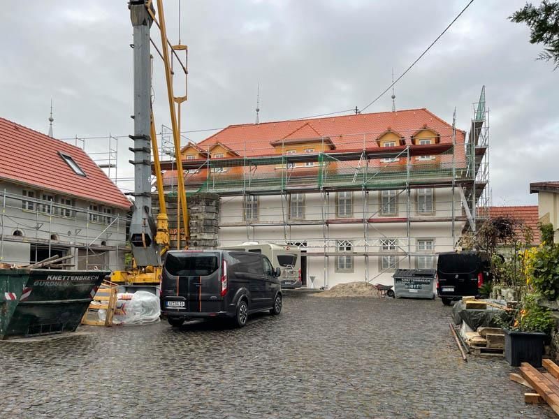 Ein Lieferwagen steht vor einem im Bau befindlichen Gebäude.