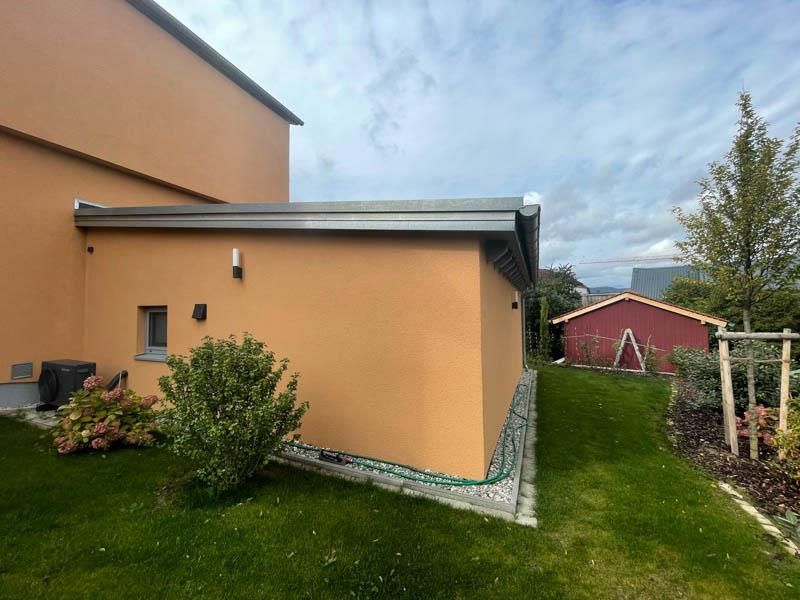 Ein großes orangefarbenes Gebäude mit einer roten Scheune im Hintergrund