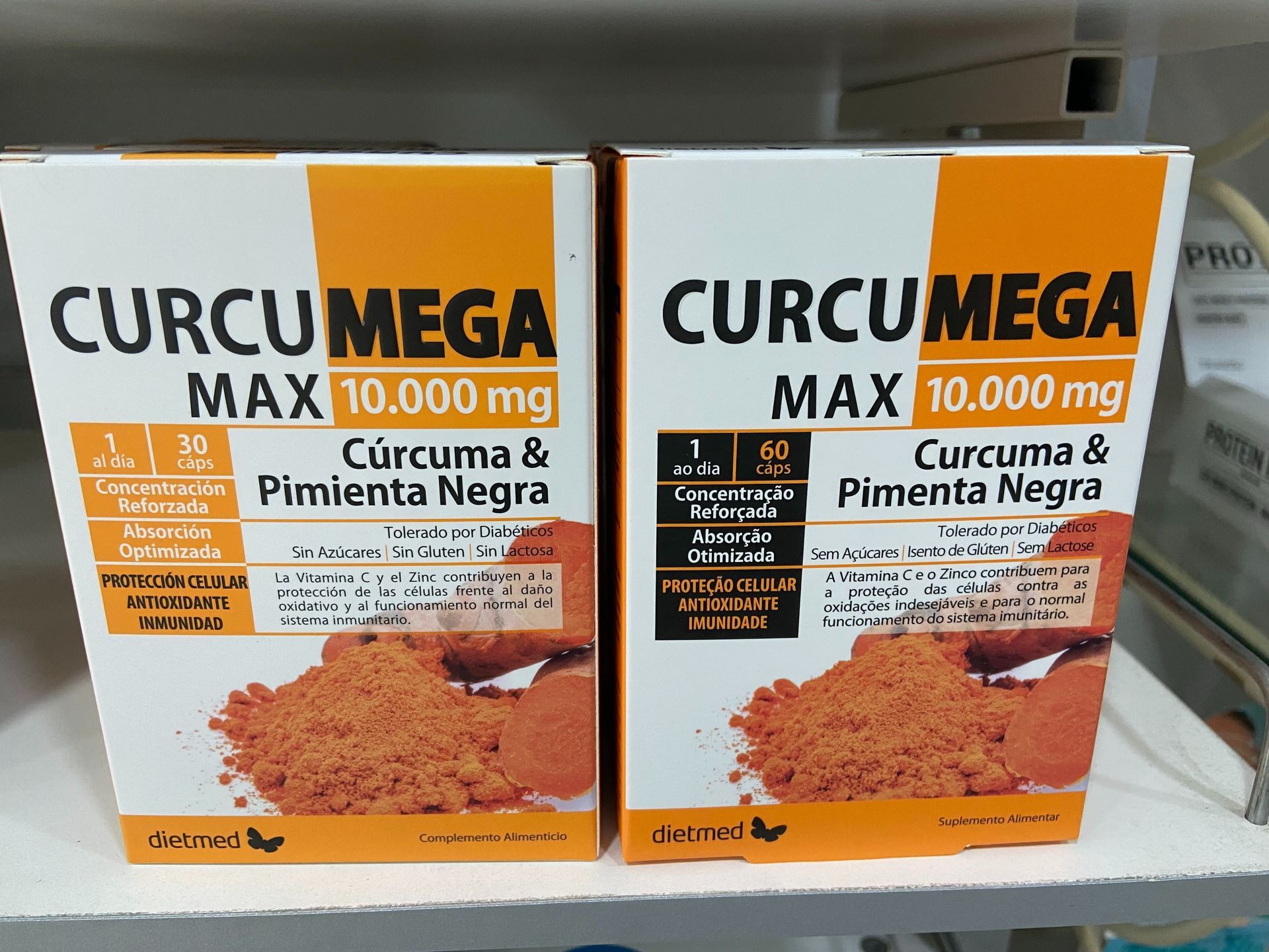 Dos cajas de cúrcuma y pimienta negra en un estante.