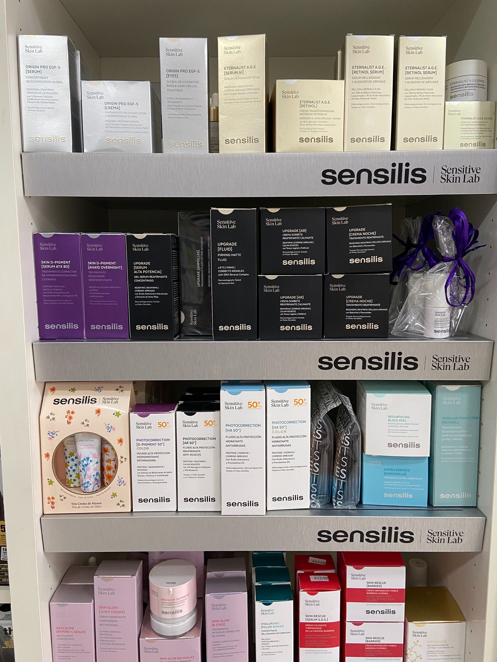 Un estante lleno de cajas de productos para la piel Sensilis.