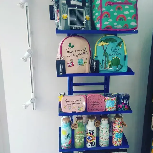 Un estante lleno de botellas de agua y mochilas, incluida una que dice amor.