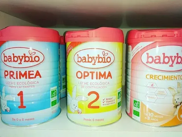 Three cans of babybio primea optima and crecimiento are on a shelf