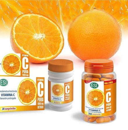 Una botella de vitamina C está rodeada de naranjas.