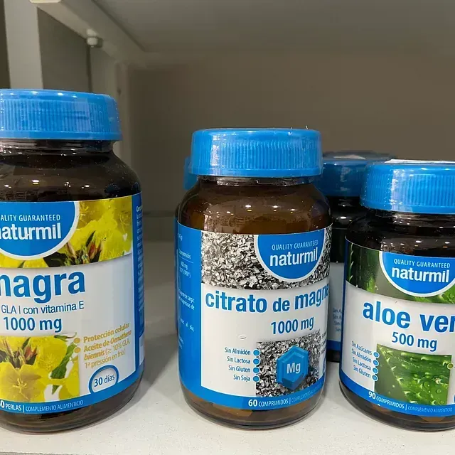 Tres botellas de vitaminas Naturmil se encuentran en un estante.