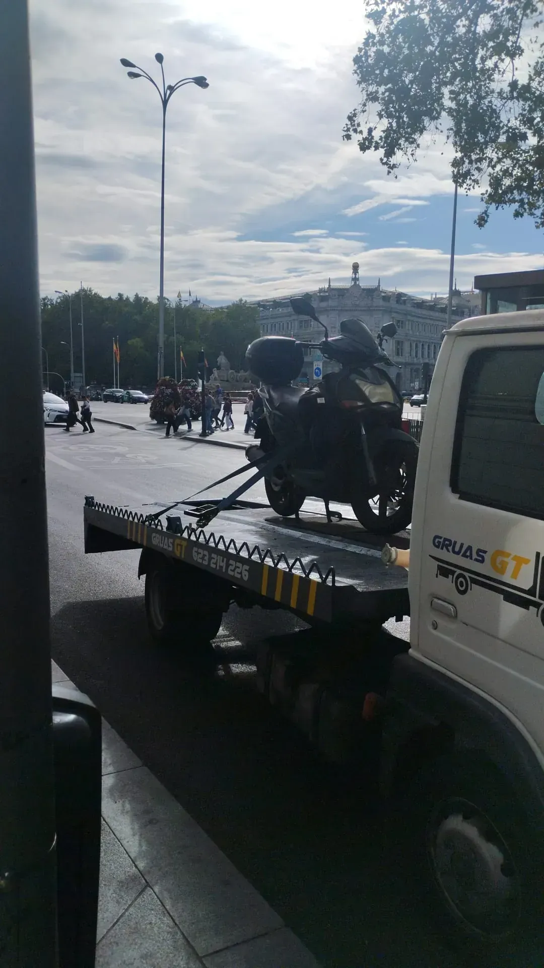 Una motocicleta sobre una grúa, estacionada en una calle de la ciudad.