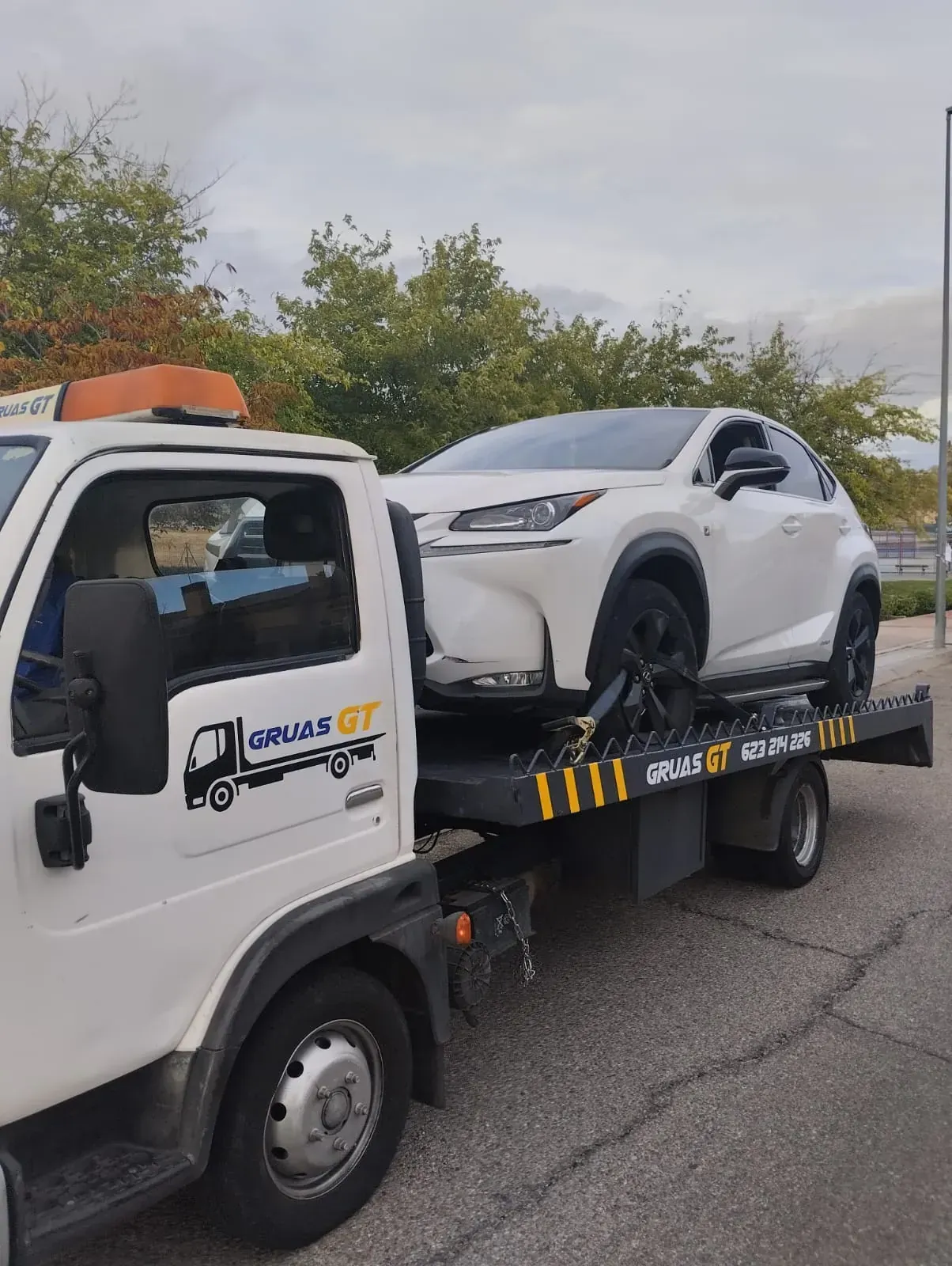 Una motocicleta sobre una grúa, estacionada en una calle de la ciudad.