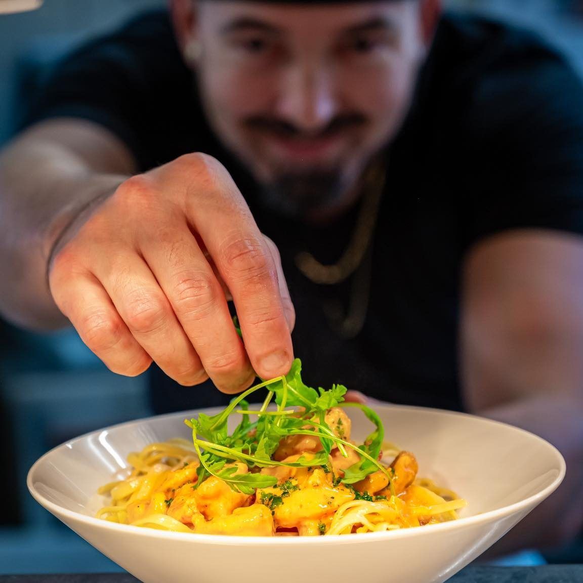 Une personne finissant de cuisiner un plat.