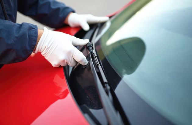 Bras robotisé pulvérisant de la peinture sur une voiture dans une usine automobile.