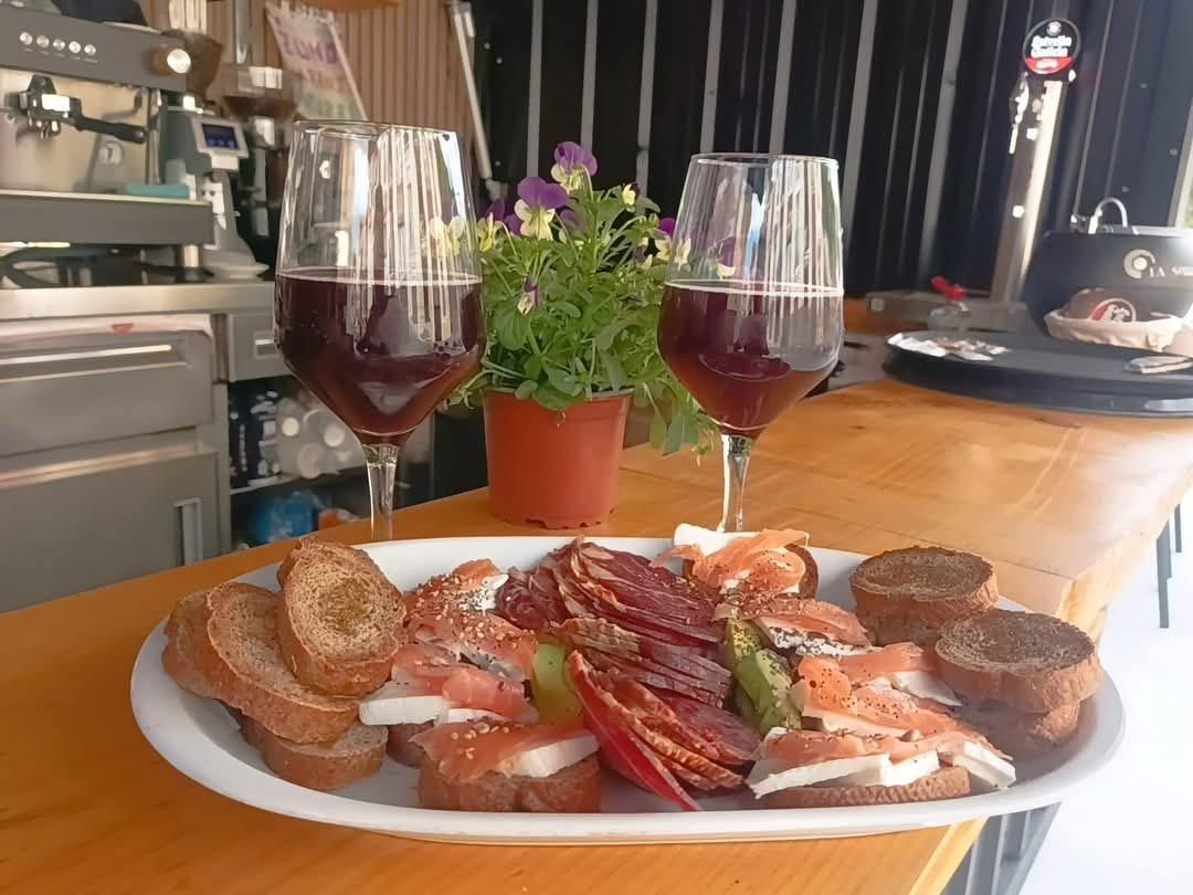 Un plato de comida y dos copas de vino en una mesa.
