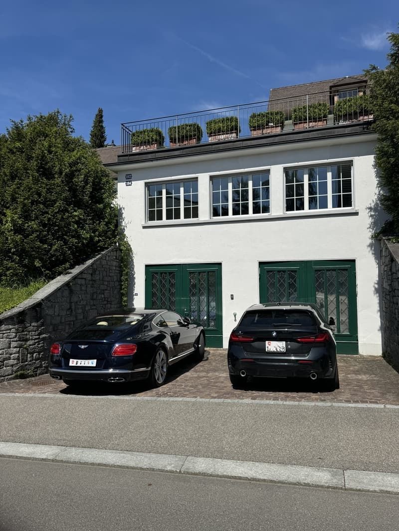 Zwei Autos parken vor einem weissen Haus. Foto von der Bruppacher Verwaltungs AG