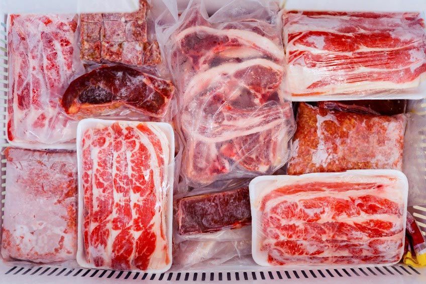 Un refrigerador lleno de una variedad de carnes congeladas.