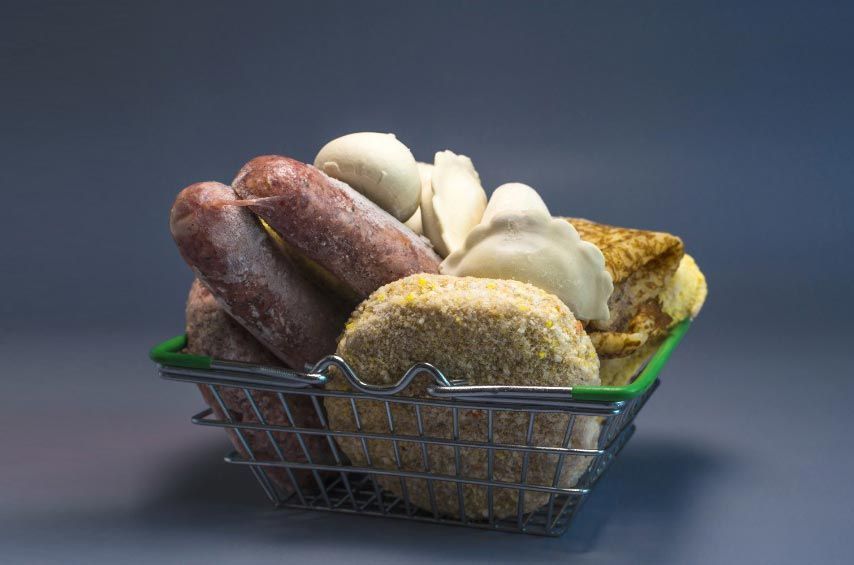 Una cesta de compra llena de diferentes tipos de alimentos.