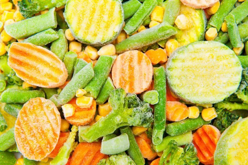 Un primer plano de una pila de verduras congeladas.