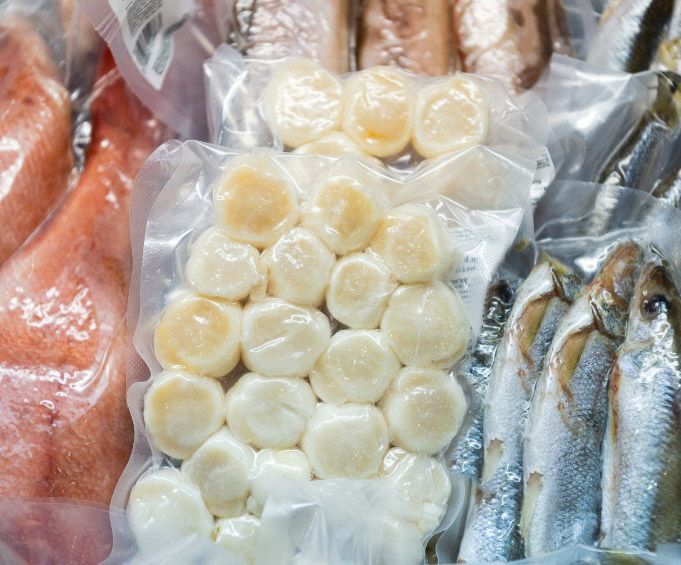 Una bolsa sellada al vacío de mariscos que incluye vieiras y sardinas