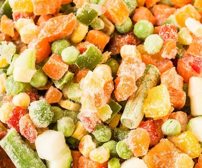 Un primer plano de una pila de verduras congeladas.