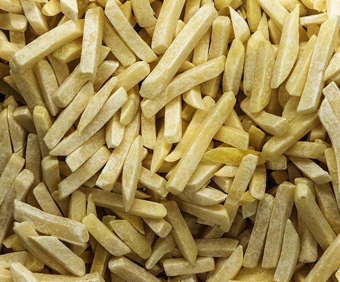 Una pila de patatas fritas congeladas sobre una mesa.