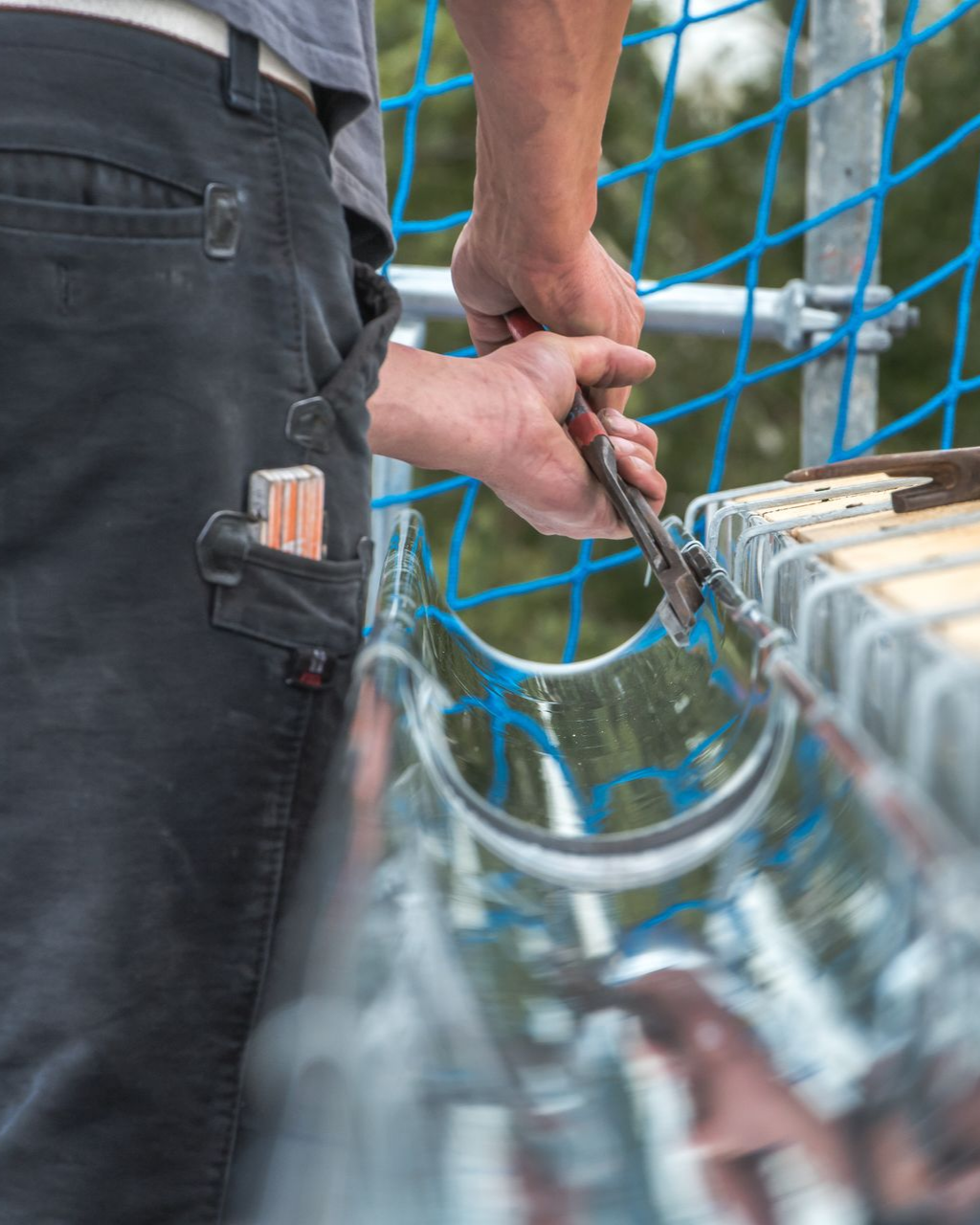 Un couvreur installe une gouttière.