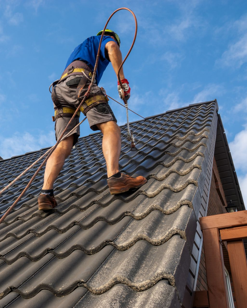 Un couvreur peint une couverture de toit.