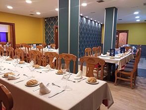 Un restaurante con mesas y sillas preparadas para una cena.