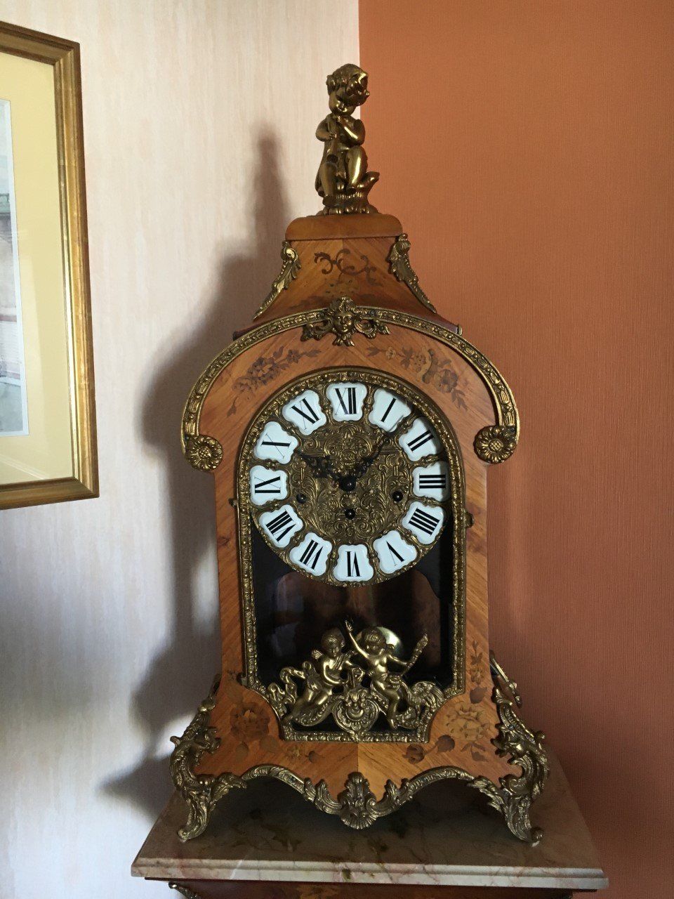 Horloge vintage sur pieds avec du bois sculpté et des dorures