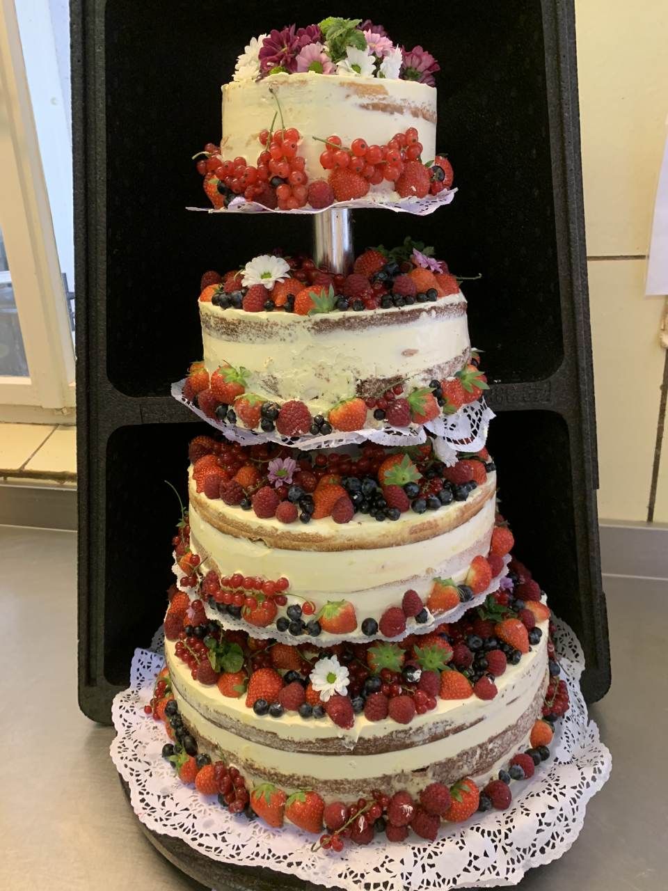 Mehrstöckige weiße Hochzeitstorte mit Obstverzierung