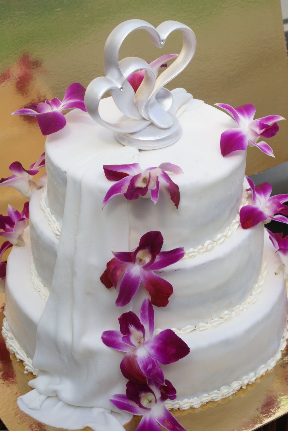 Mehrstöckige weiße Hochzeitstorte mit Echtblumen-Verzierung