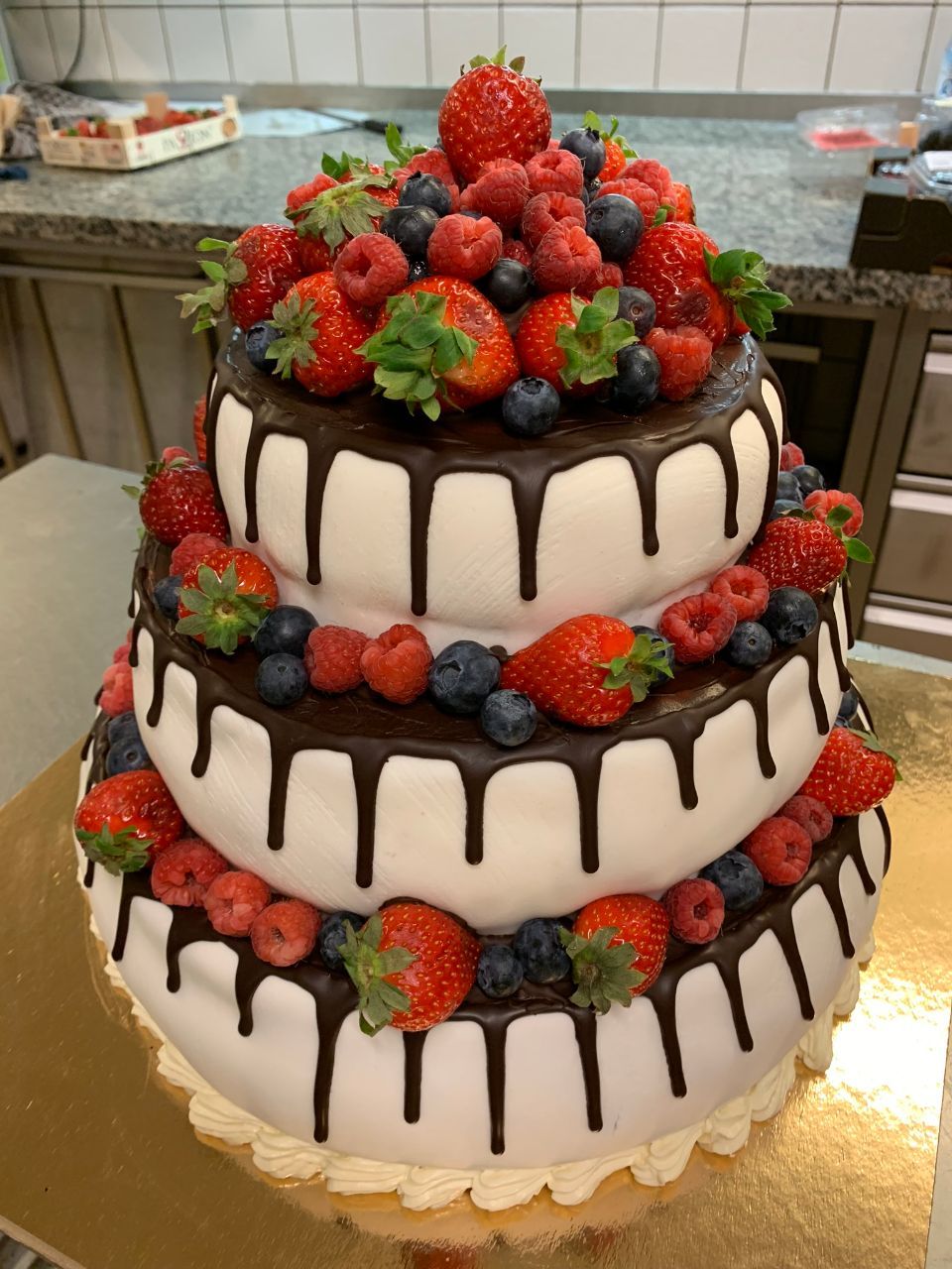 Dreistöckige Torte mit Schoko-Drip-Effekt und frischen Erdbeeren