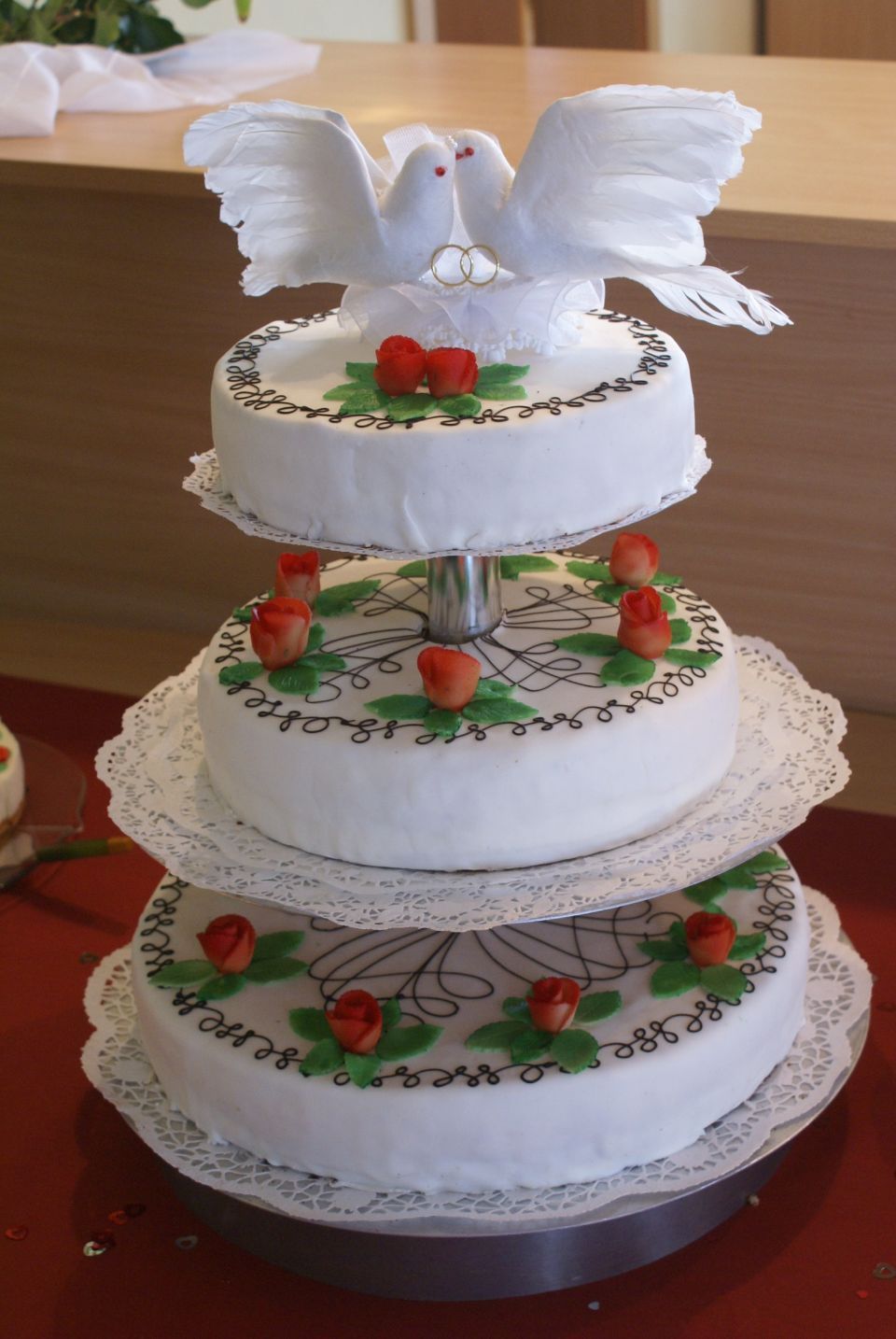 Dreistöckige Hochzeitstorte mit Blumenverzierung und Tauben