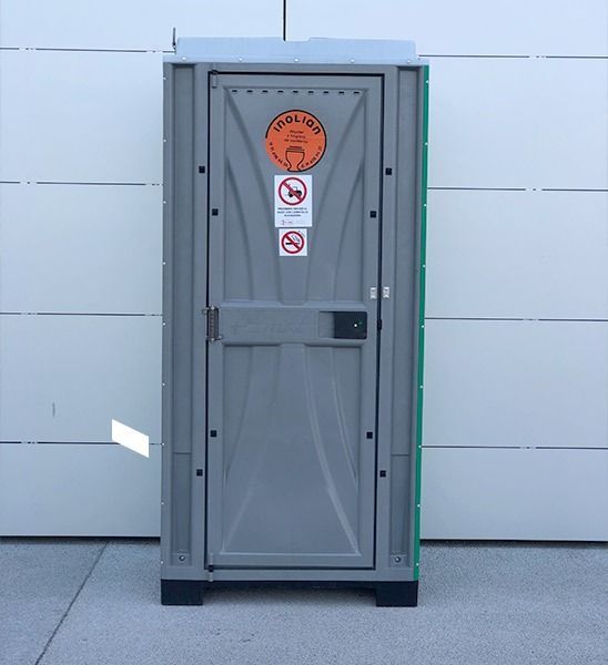 Un baño portátil tiene una pegatina en la puerta que dice